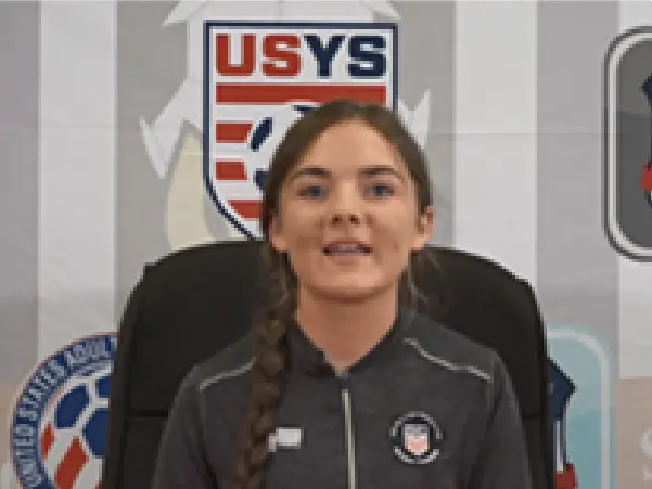 A girl in front of the u. S. Soccer logo