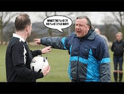 A man in blue jacket holding a soccer ball.